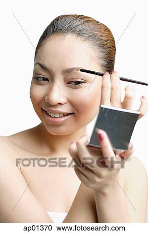 Young woman using eyebrow brush, looking at compact View Large Photo Image Stock Image - Young woman using eyebrow brush, looking at compact. Fotosearch