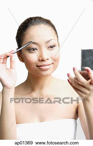 Young woman using eyebrow brush, looking at compact View Large Photo Image Stock Photo - Young woman using eyebrow brush, looking at compact. Fotosearch