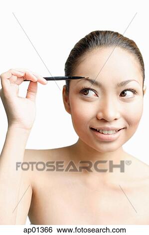 Young woman using eyebrow pencil, looking away View Large Photo Image Stock Photograph - Young woman using eyebrow pencil, looking away. Fotosearch