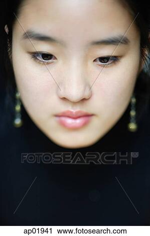 Young woman with downwards gaze, head shot View Large Photo Image Stock Image - Young woman with downwards gaze, head shot. Fotosearch
