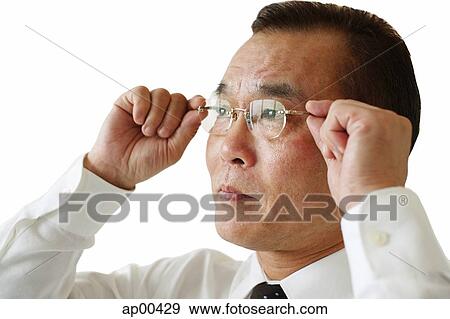 Businessman adjusting glasses, side view View Large Photo Image Stock Photo - Businessman adjusting glasses, side view. Fotosearch