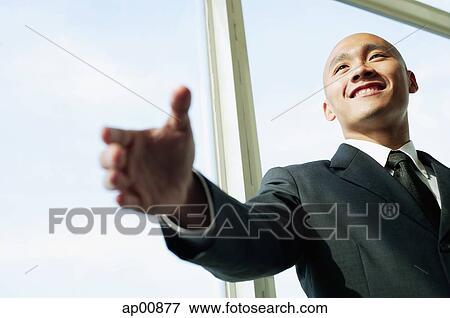 Businessman, hand outstretched, smiling View Large Photo Image Stock Photo - Businessman, hand outstretched, smiling. Fotosearch