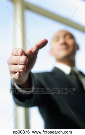 Stock Photograph - Businessman, hand outstretched, selective focus. Fotosearch