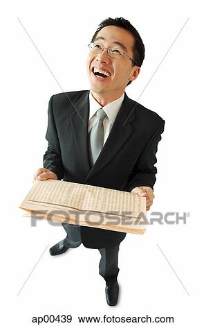 Businessman holding newspaper, laughing View Large Photo Image Stock Photo - Businessman holding newspaper, laughing. Fotosearch