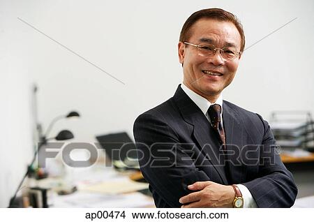 Picture - Businessman with arms crossed, looking at camera, portrait. Fotosearch