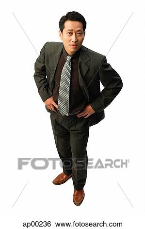 Stock Photograph - Businessman with hands on hips, looking at camera. Fotosearch