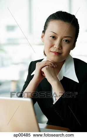 Businesswoman looking at camera, hands clasped View Large Photo Image Stock Photography - Businesswoman looking at camera, hands clasped. Fotosearch