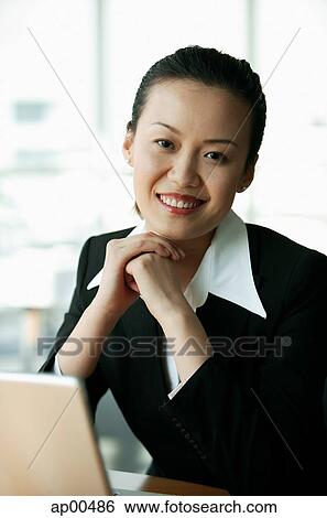 Businesswoman smiling at camera, hands clasped View Large Photo Image Stock Photograph - Businesswoman smiling at camera, hands clasped. Fotosearch