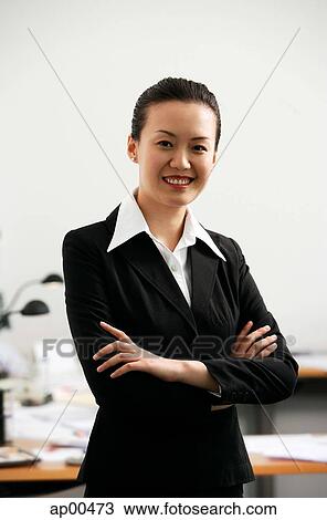 Businesswoman standing with arms crossed, smiling at camera View Large Photo Image Stock Image - Businesswoman standing with arms crossed, smiling at camera. Fotosearch