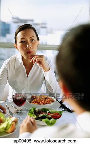 Businesswoman with hand on chin, facing another person View Large Photo Image Stock Photography - Businesswoman with hand on chin, facing another person. Fotosearch