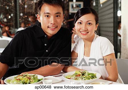 Couple at restaurant, side by side, looking at camera View Large Photo Image Stock Photo - Couple at restaurant, side by side, looking at camera. Fotosearch