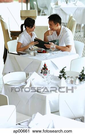 Couple in restaurant, holding menu View Large Photo Image Stock Image - Couple in restaurant, holding menu. Fotosearch