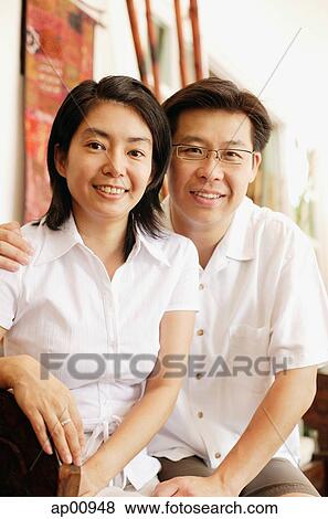 Stock Photo - Couple looking at camera, portrait. Fotosearch