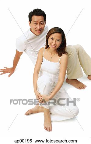 Couple sitting on floor, looking up at camera View Large Photo Image Stock Photography - Couple sitting on floor, looking up at camera. Fotosearch
