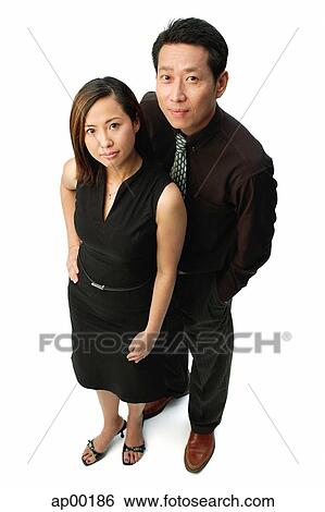 Stock Photograph - Couple standing, looking at camera, portrait. Fotosearch