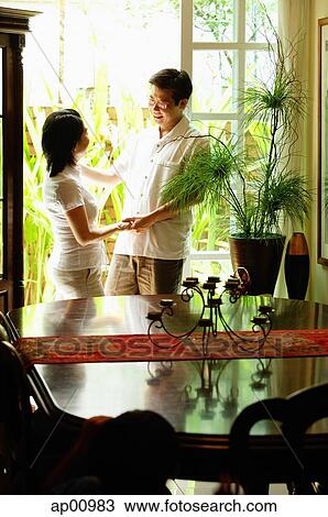 Stock Image - Couple standing, looking at each other. Fotosearch