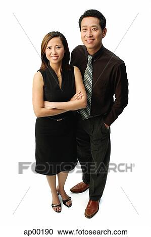 Couple standing, smiling at camera, woman with arms crossed View Large Photo Image Stock Image - Couple standing, smiling at camera, woman with arms crossed. Fotosearch