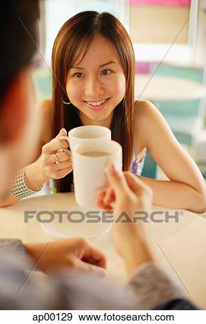 Couple with holding mugs, facing each other, over the shoulder view View Large Photo Image Stock Photo - Couple with holding mugs, facing each other, over the shoulder view. Fotosearch