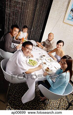 Stock Photo - Couples eating at restaurant, looking at camera. Fotosearch