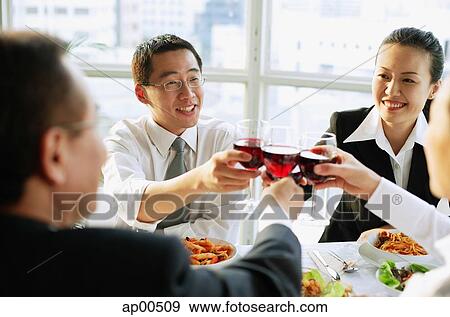 Executives at restaurant, toasting with wine View Large Photo Image Stock Photo - Executives at restaurant, toasting with wine. Fotosearch