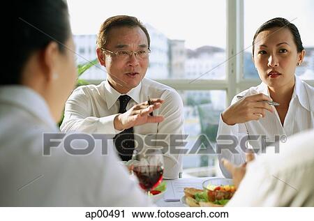 Executives having lunch meeting, over the shoulder view View Large Photo Image Stock Image - Executives having lunch meeting, over the shoulder view. Fotosearch