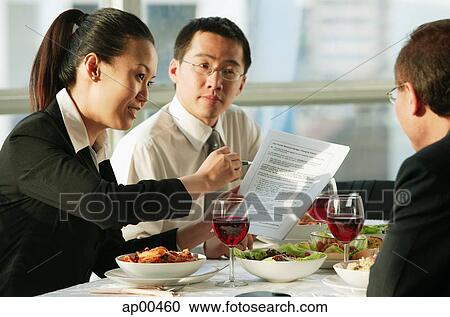 Stock Image - Executives having lunch meeting. Fotosearch