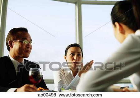 Stock Photo - Executives having lunch meeting. Fotosearch