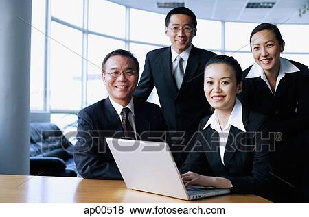 Executives looking at camera, laptop open in front of them View Large Photo Image Stock Photo - Executives looking at camera, laptop open in front of them. Fotosearch