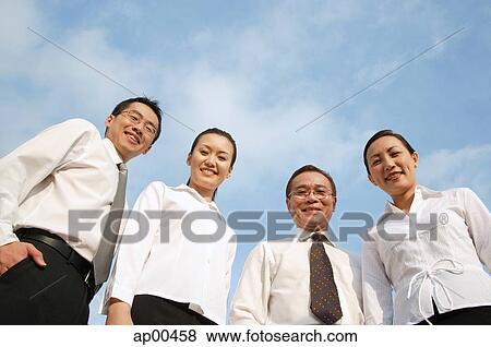 Executives looking down at camera, smiling View Large Photo Image Stock Photo - Executives looking down at camera, smiling. Fotosearch