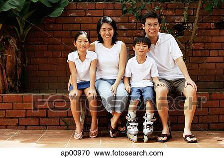 Family with two children, sitting, looking at camera View Large Photo Image Stock Image - Family with two children, sitting, looking at camera. Fotosearch