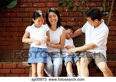 Stock Image - Father and mother with two children, fooling around. Fotosearch