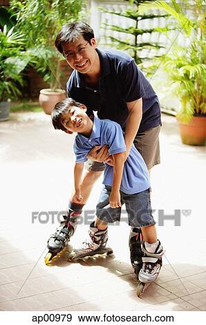 Father and son standing, wearing in-line skates, looking at camera View Large Photo Image Stock Photo - Father and son standing, wearing in-line skates, looking at camera. Fotosearch