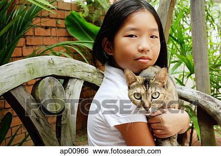 Girl holding cat, looking at camera View Large Photo Image Stock Photograph - Girl holding cat, looking at camera. Fotosearch