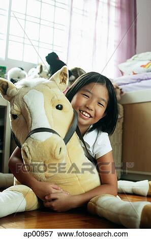 Girl in bedroom, hugging stuffed toy View Large Photo Image Stock Photo - Girl in bedroom, hugging stuffed toy. Fotosearch