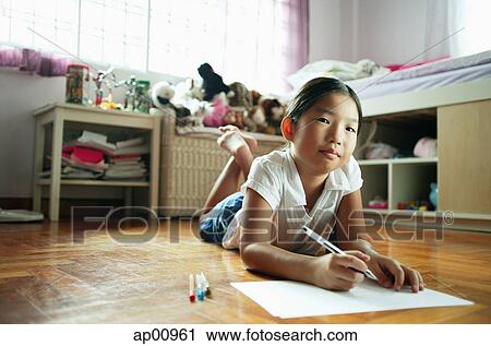 Girl in bedroom, lying on floor, holding pen, looking at camera View Large Photo Image Stock Image - Girl in bedroom, lying on floor, holding pen, looking at camera. Fotosearch