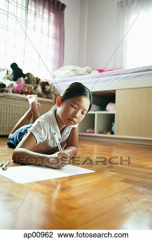 Girl in bedroom, lying on floor, drawing on paper View Large Photo Image Stock Image - Girl in bedroom, lying on floor, drawing on paper. Fotosearch