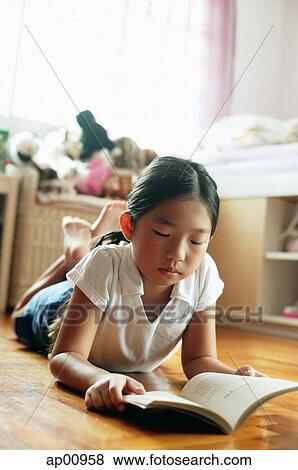 Girl in bedroom, lying on floor, reading book View Large Photo Image Stock Photo - Girl in bedroom, lying on floor, reading book. Fotosearch