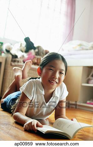 Girl in bedroom, lying on floor, with book, looking at camera View Large Photo Image Stock Photo - Girl in bedroom, lying on floor, with book, looking at camera. Fotosearch