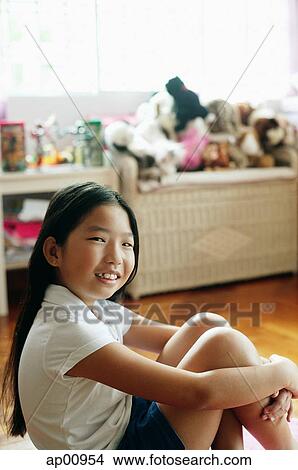 Girl in bedroom, sitting on floor, hugging knees, looking at camera View Large Photo Image Picture - Girl in bedroom, sitting on floor, hugging knees, looking at camera. Fotosearch