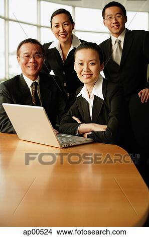 Picture - Group of executives, in boardroom, smiling at camera, portrait. Fotosearch