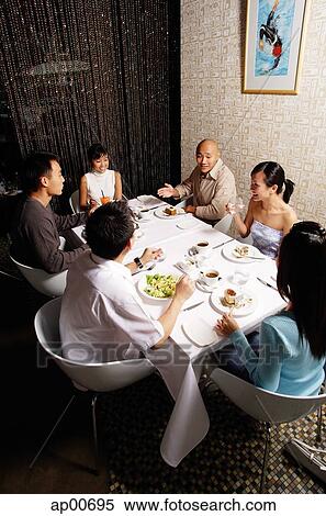 Stock Photography - Group of friends having dinner at restaurant. Fotosearch