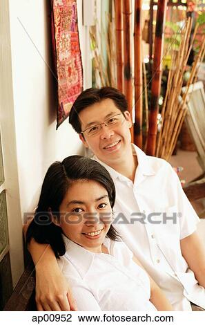 Stock Image - Husband and wife looking up at camera, portrait. Fotosearch