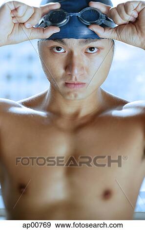 Man adjusting swimming goggles, looking at camera View Large Photo Image Stock Photo - Man adjusting swimming goggles, looking at camera. Fotosearch