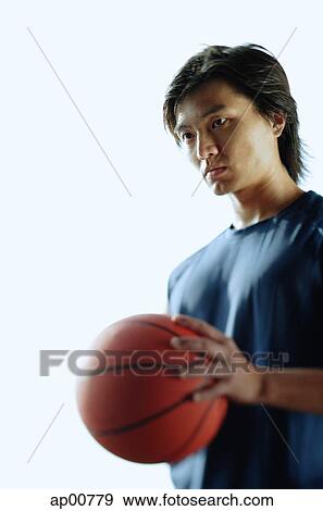 Man holding basketball, looking away View Large Photo Image Stock Photo - Man holding basketball, looking away. Fotosearch
