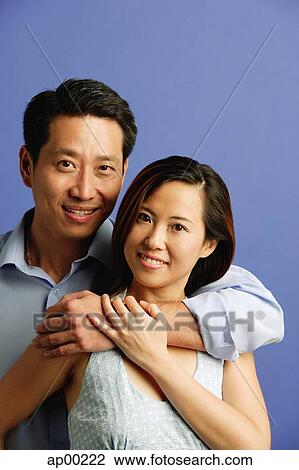 Man hugging woman, both facing camera, portrait View Large Photo Image Stock Image - Man hugging woman, both facing camera, portrait. Fotosearch