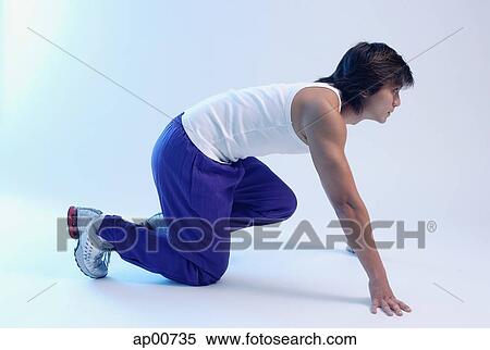 Man kneeling at starting position, looking up, side view View Large Photo Image Stock Photography - Man kneeling at starting position, looking up, side view. Fotosearch
