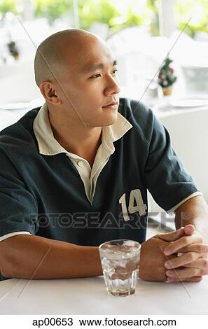 Man looking away, glass of water on table next to him View Large Photo Image Stock Image - Man looking away, glass of water on table next to him. Fotosearch