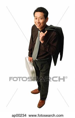 Picture - Man standing carrying jacket and briefcase, smiling at camera. Fotosearch