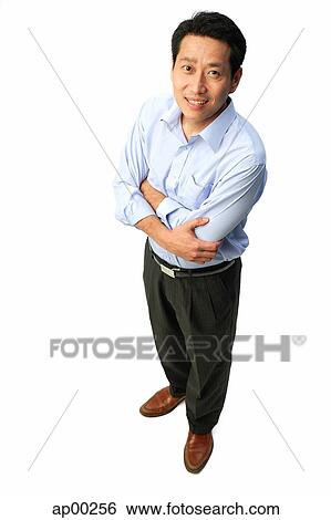 Stock Photograph - Man standing with arms crossed, smiling at camera. Fotosearch