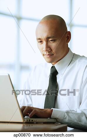 Stock Image - Man using computer, portrait. Fotosearch